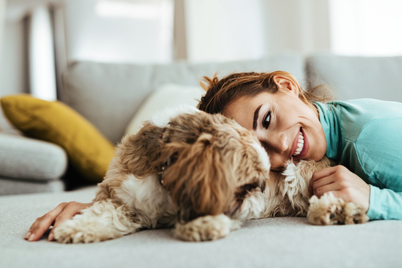 A woman cuddling her dog at home