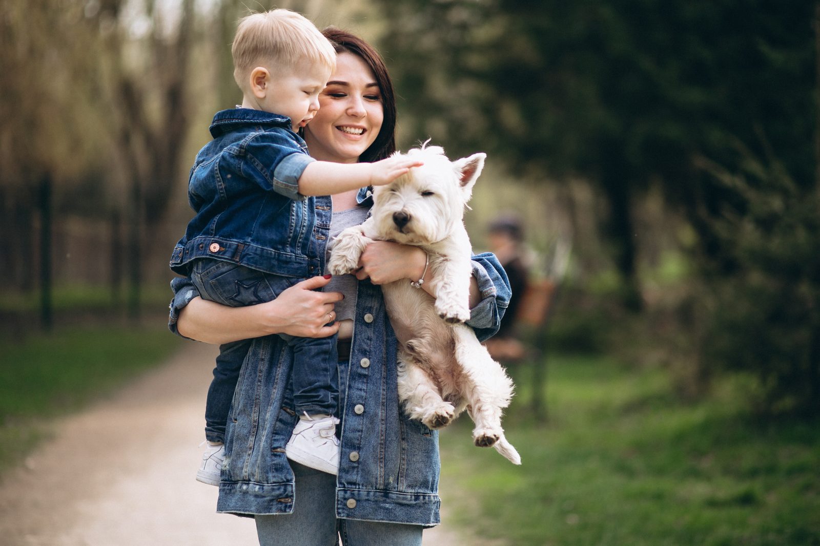 A mother and son with their dog outdoors